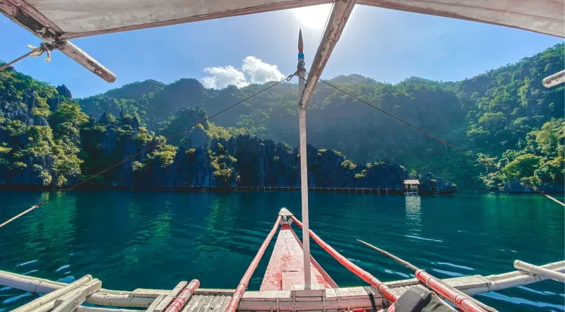 View from the bow of a traditional bangka outrigger boat approaching Kayangan Lake, Coron Philippines