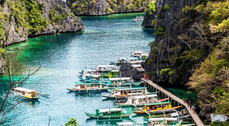 Colourful outrigger boats lined up at Kayangan Lake dock, Coron Island Philippines